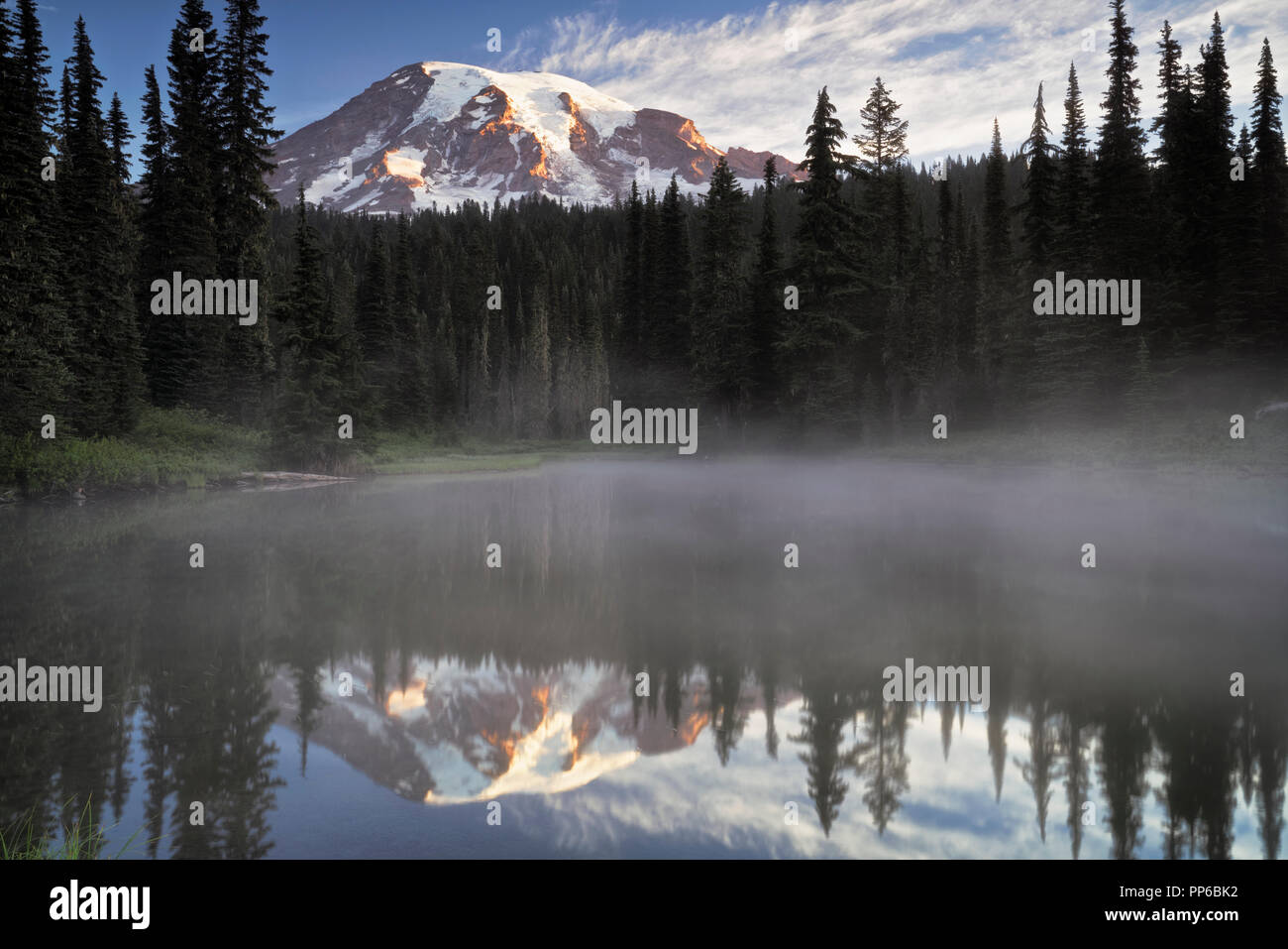 First light glow on Washington’s Mt Rainier from the aptly named Reflection Lakes in Mount Rainier National Park. Stock Photo