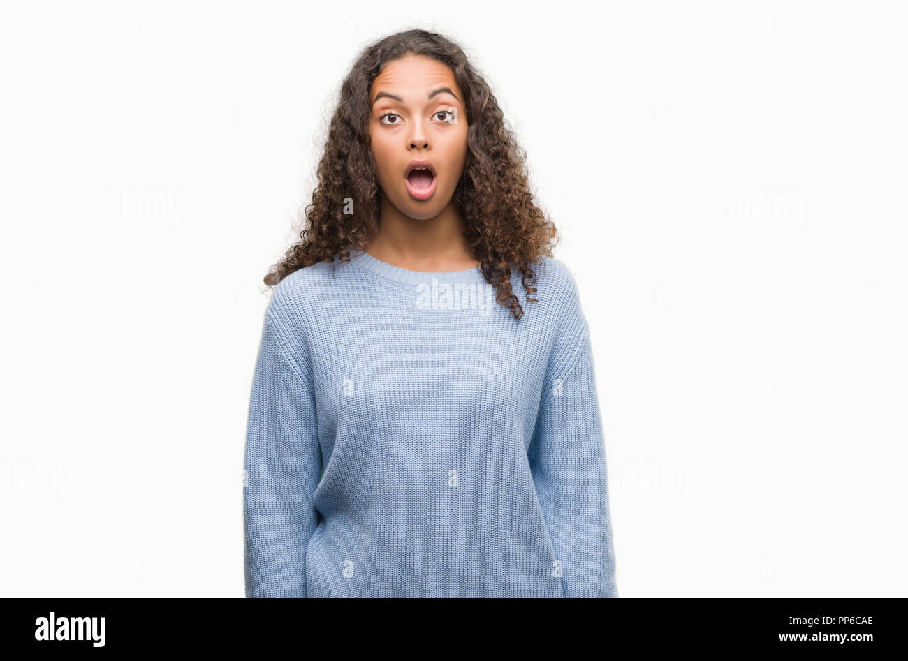 Beautiful young hispanic woman scared in shock with a surprise face ...
