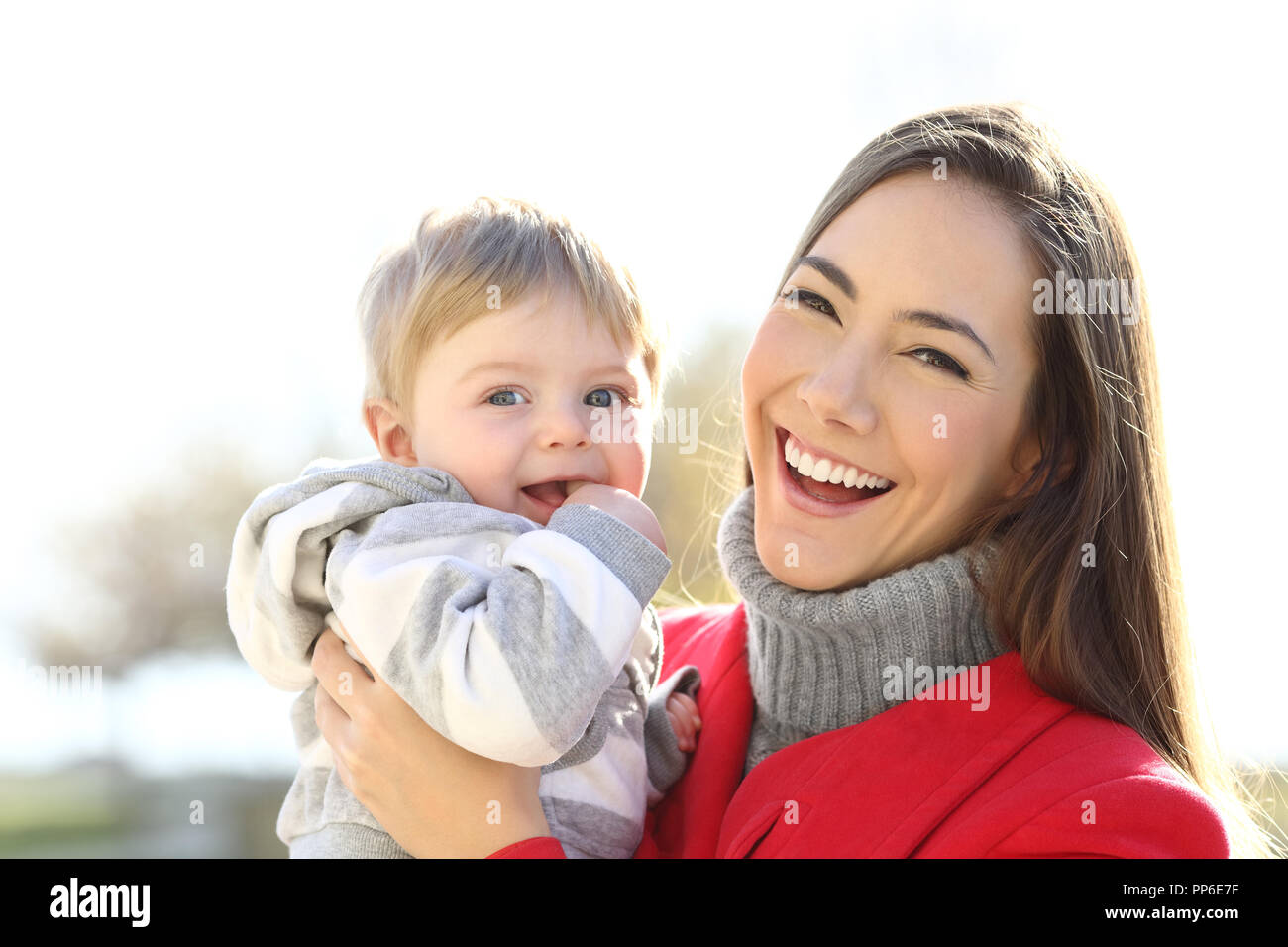 Portrait of a happy baby and mother posing looking at camera outdoors in winter Stock Photo