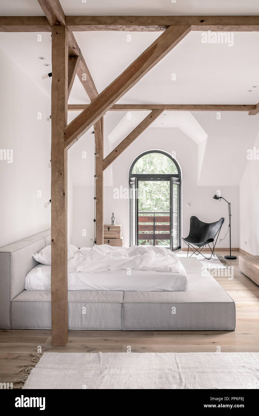 Bedroom In A Modern Style With White Walls Wooden Beams And