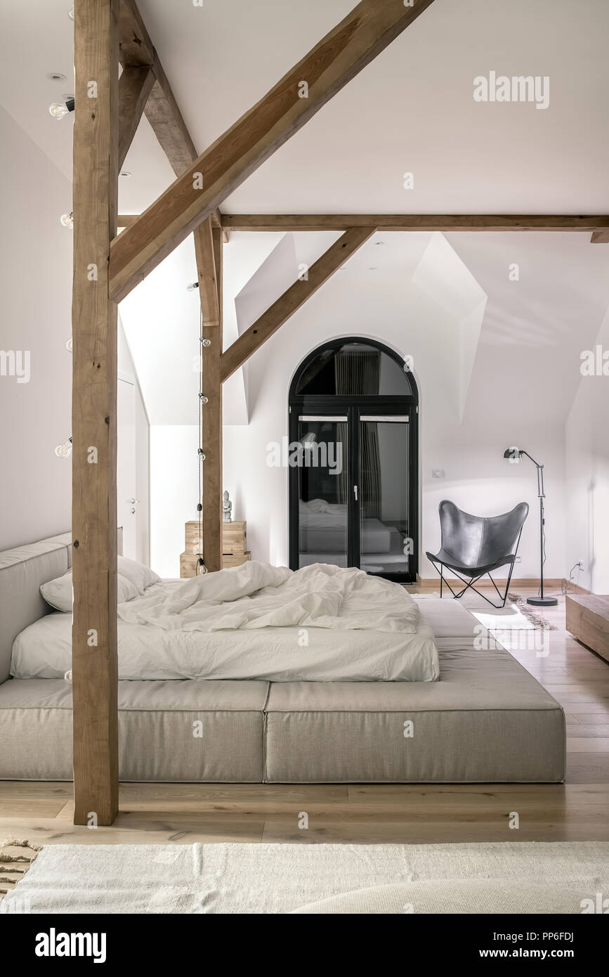 Trendy Modern Bedroom With White Walls Wooden Beams And A