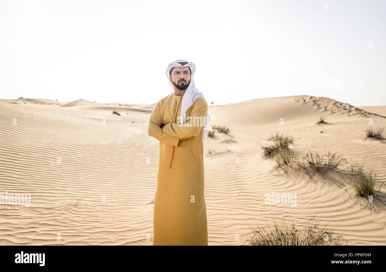 Handsome arabian man with traditional dress in the desert of Dubai ...