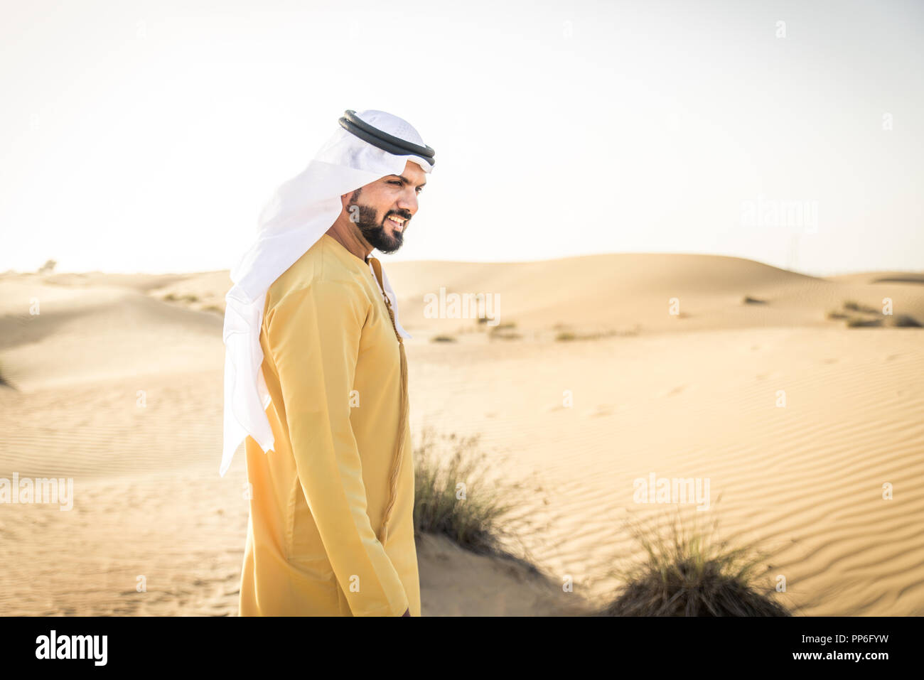 Handsome arabian man with traditional dress in the desert of Dubai ...