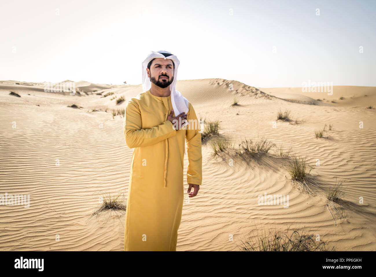 Handsome arabian man with traditional dress in the desert of Dubai ...
