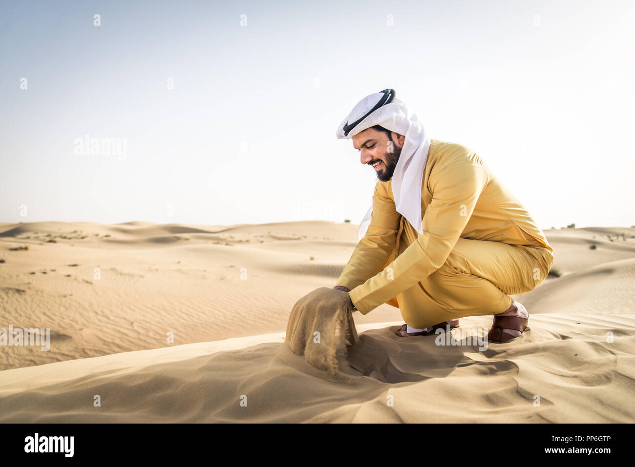 Handsome arabian man with traditional dress in the desert of Dubai ...