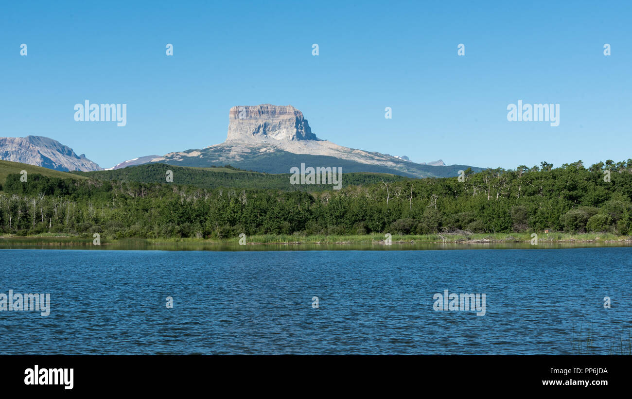 Old Chief Mountain overlooking Police Outpost Lake in South West Alberta near Waterton National Park Stock Photo