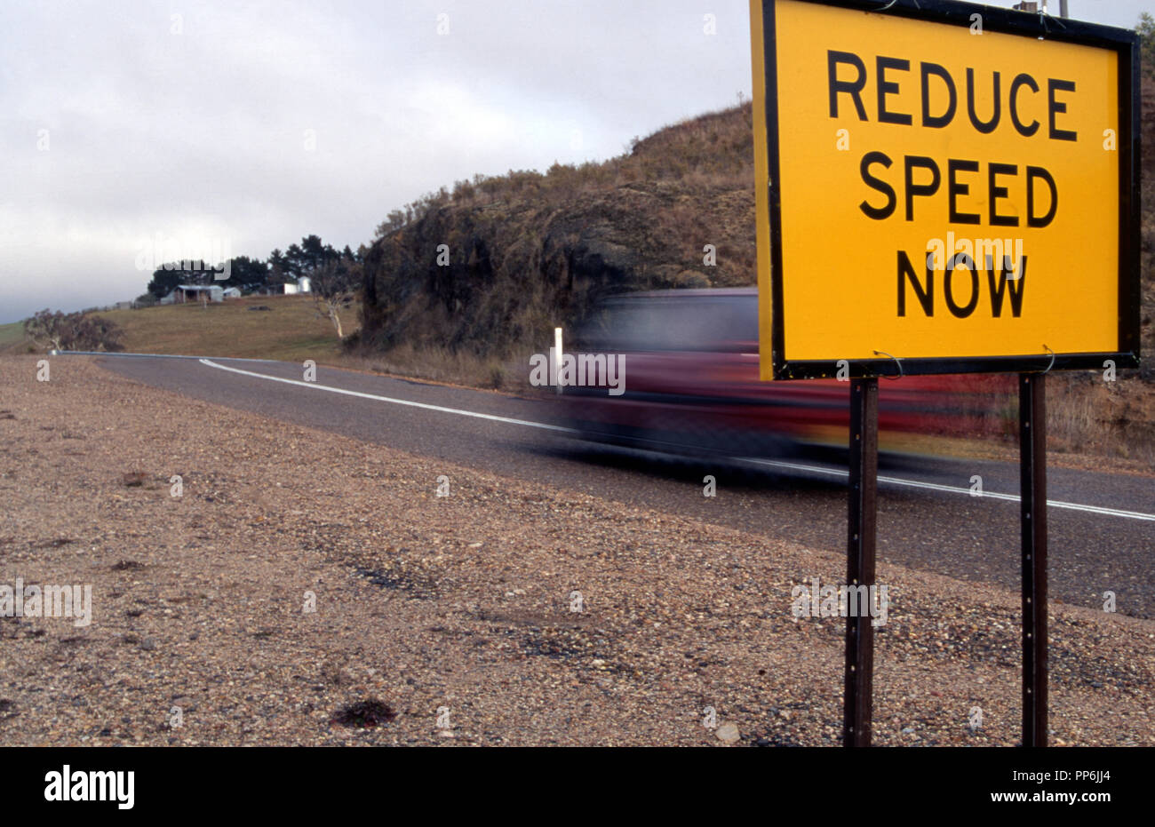 Reduce speed now sign on a country road in New South Wales, Australia Stock Photo