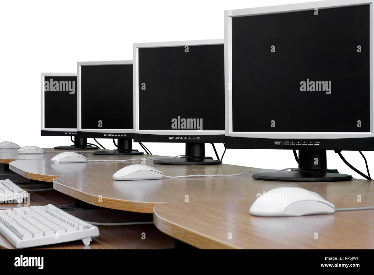 Row of computer monitors in classroom. White background, isolated Stock