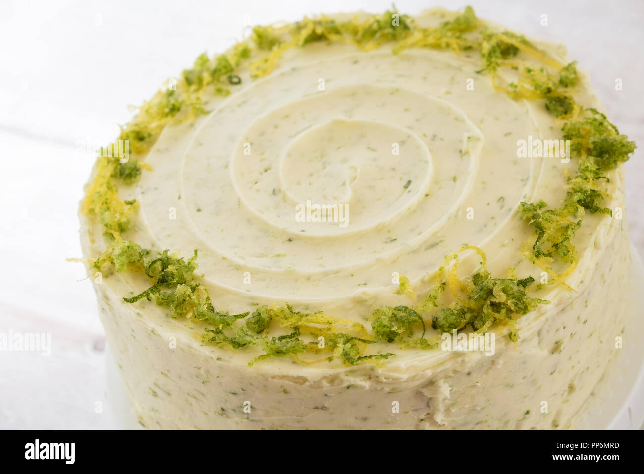 High angle view of a baked gin and tonic flavoured cake with icing and lime zest decoration Stock Photo
