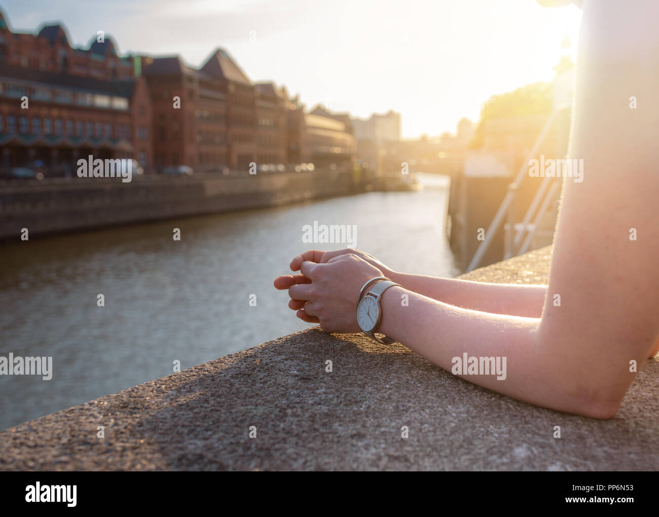partial view of woman resting her arms on quay wall Stock Photo