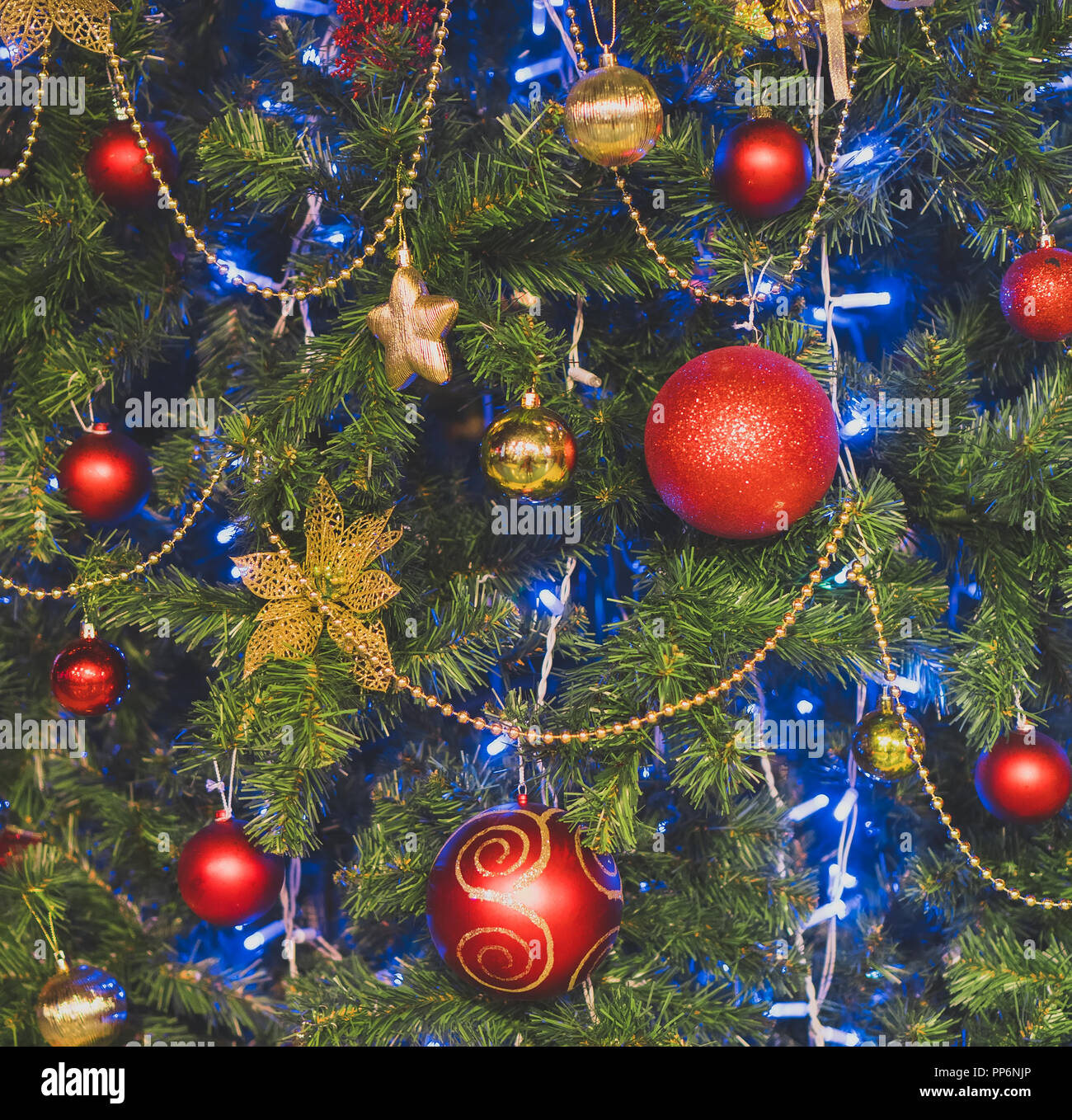 Artificial Christmas tree with garlands and balls Stock Photo - Alamy