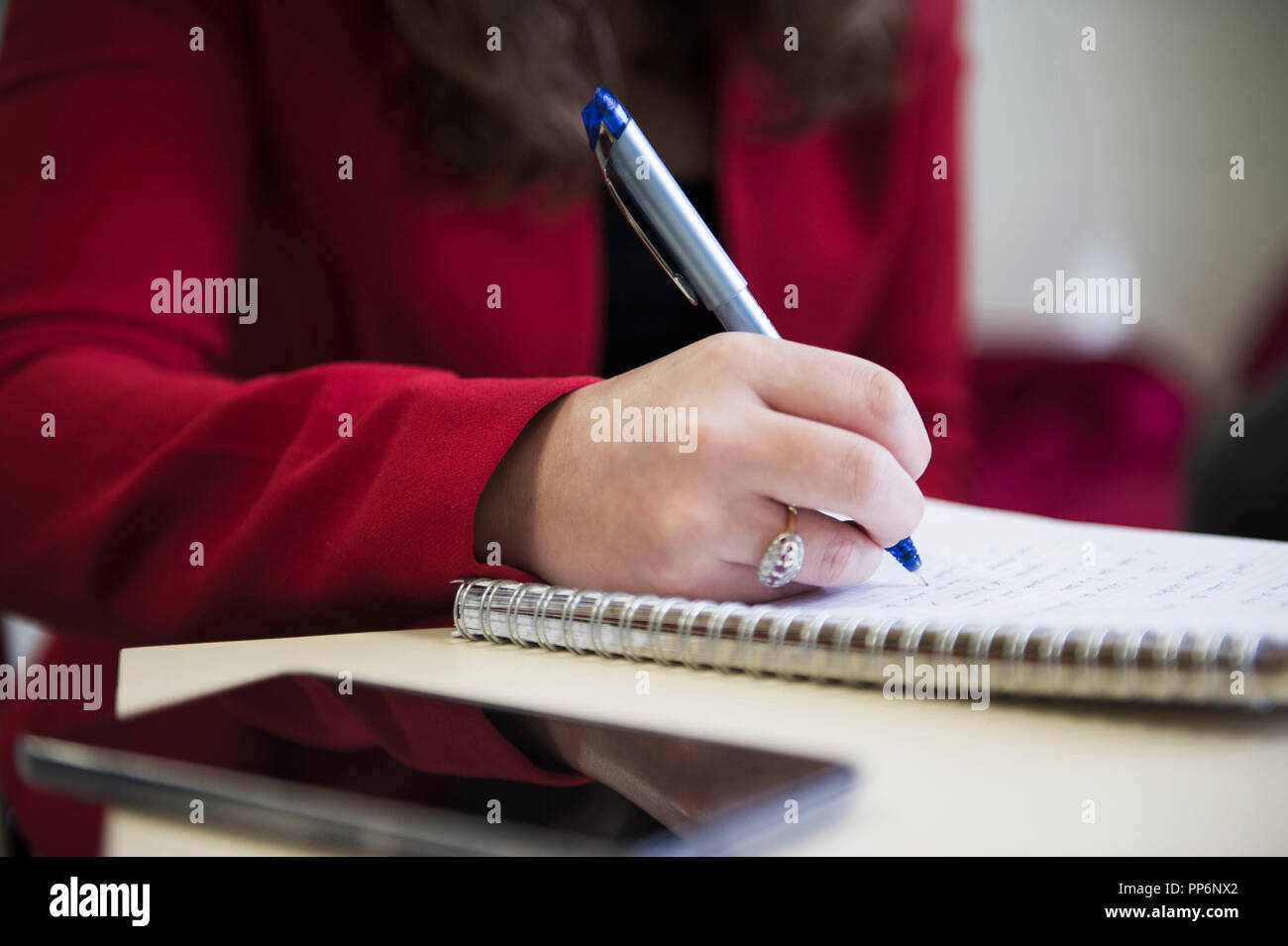 Note-taking on a notebook with a pen during a business meeting Stock Photo