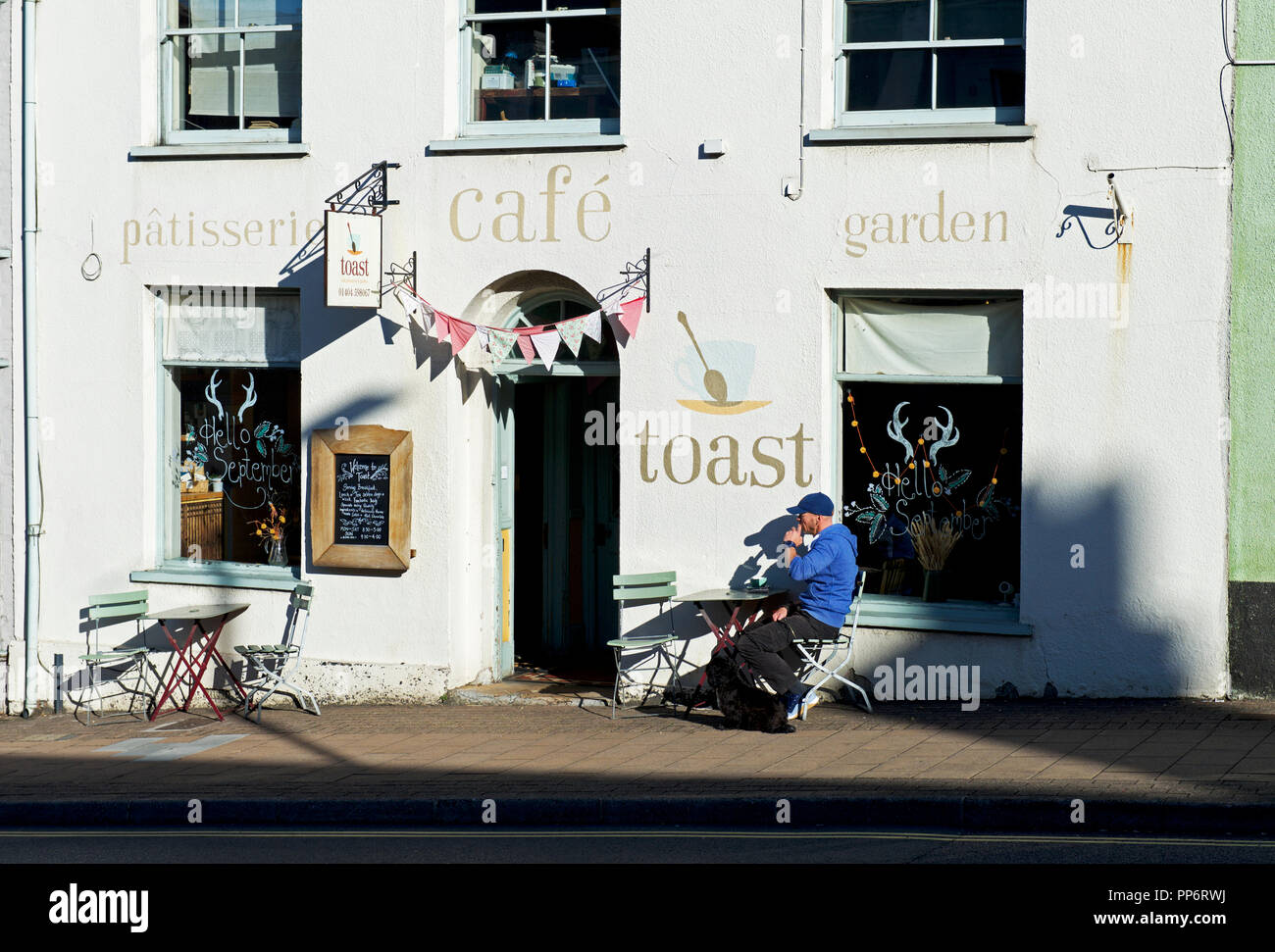 Man sitting outside Toast Café, Honiton, Devon, England UK Stock Photo