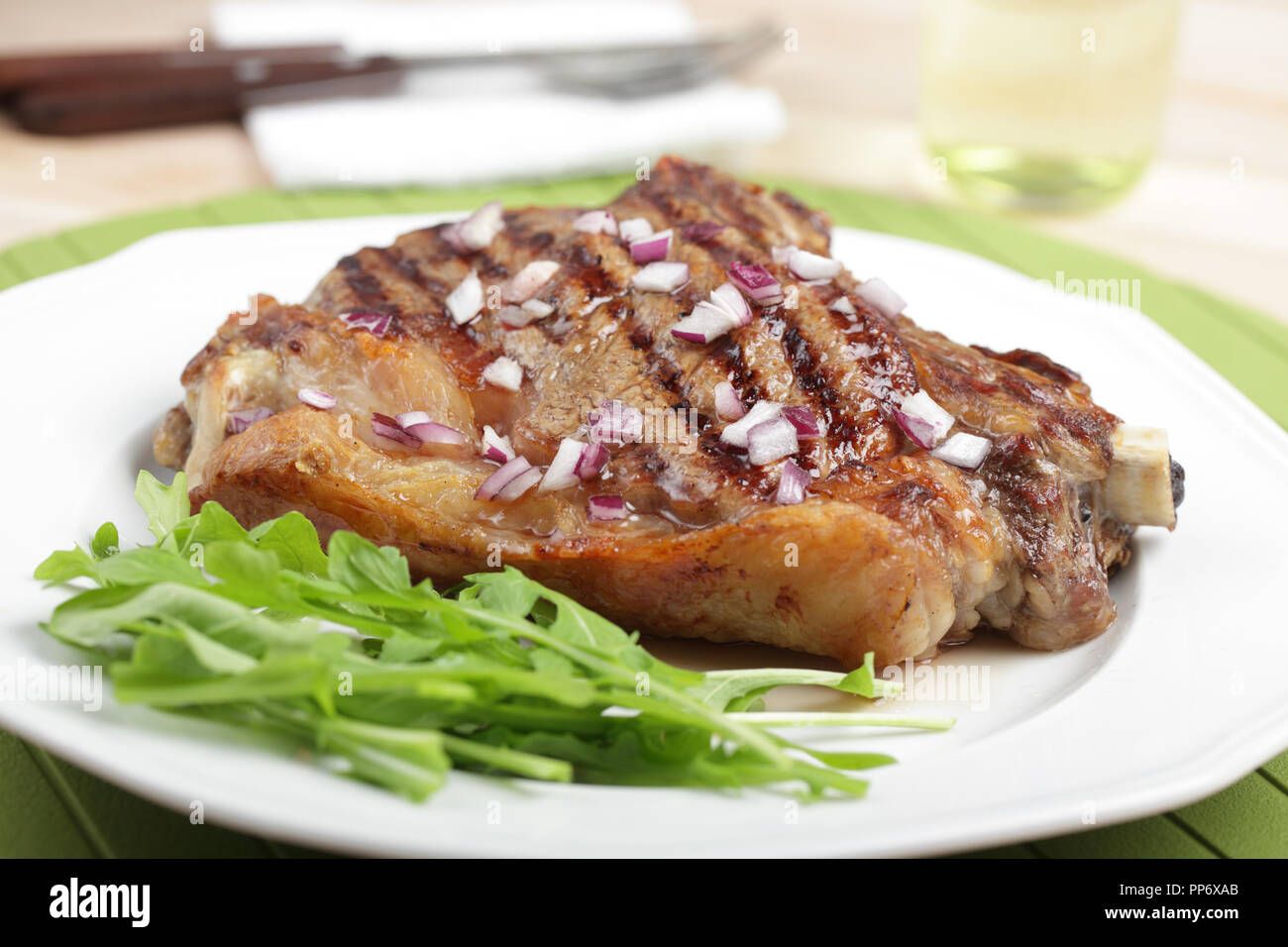 Grilled rib steak with red onion and rocket salad Stock Photo - Alamy