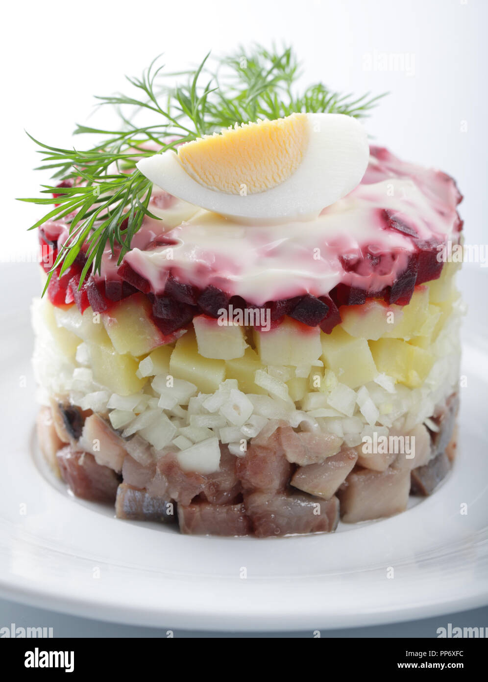 Russian herring salad with potatoes and beetroot on the white plate closeup Stock Photo