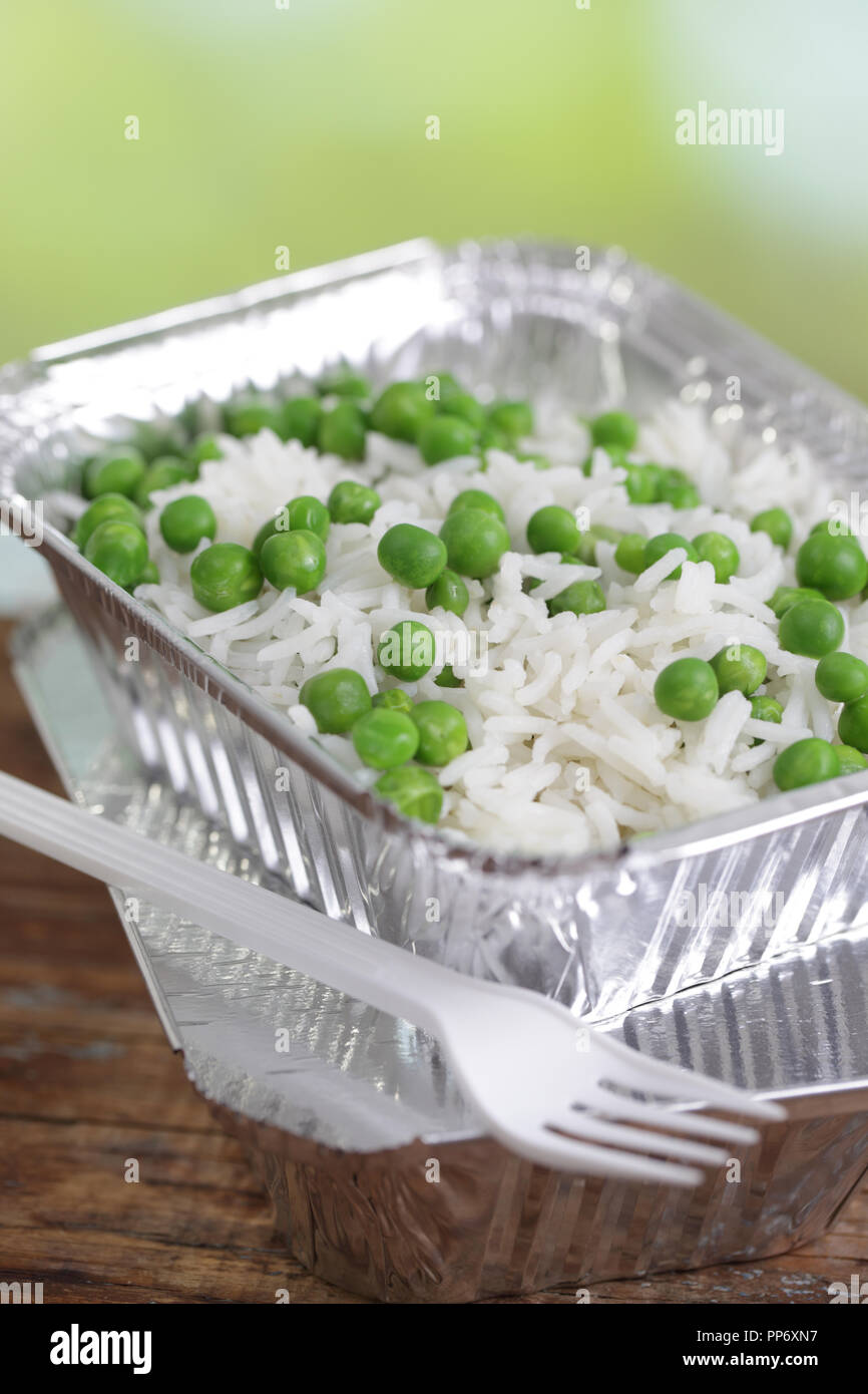Basmati rice with green peas in the disposable aluminum pan Stock Photo