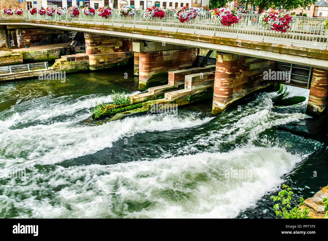 Sprays of flowers line the walkway over the Rue SainteMarguerite