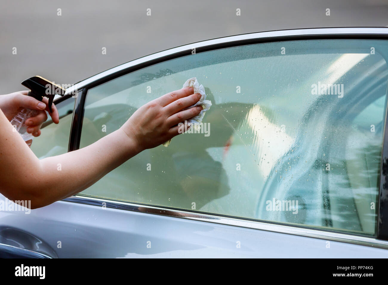 Car Care Woman washing a car by hand using microfiber cloth cleaning