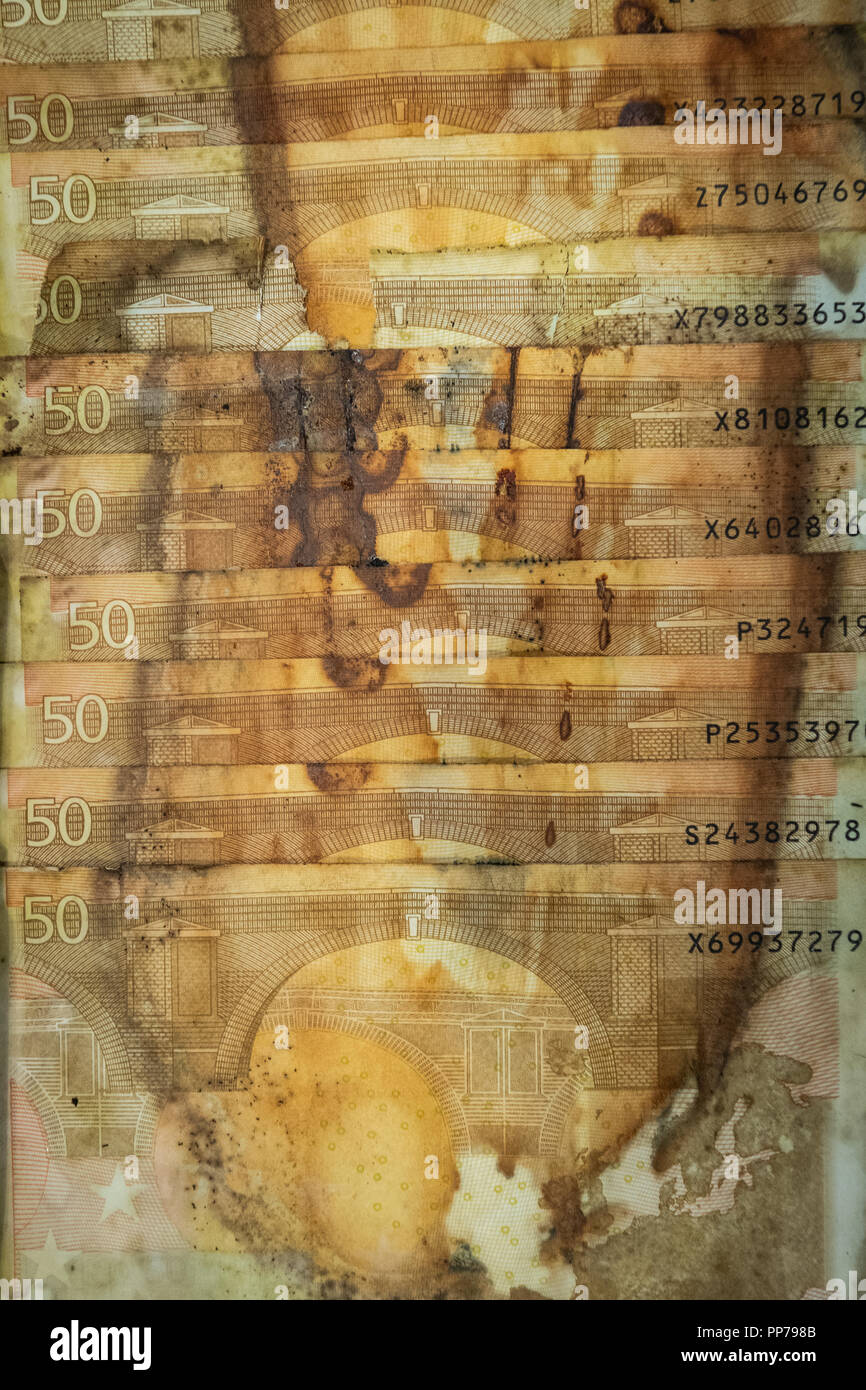 19 September 2018, Rhineland-Palatinate, Mainz: 50 euro banknotes are lined up in a wooden tray in the Bundesbank's National Analysis Centre. The money has been damaged by moisture, the brownish discolouration comes from a paper clip. The money was buried in a garden by a private person as a nest egg. Photo: Silas Stein/dpa Stock Photo