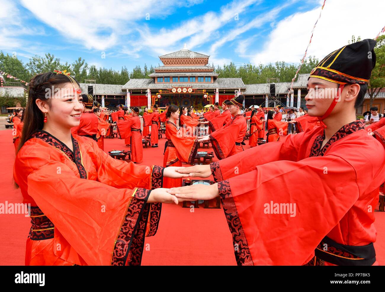 Wuhu, China's Anhui Province. 23rd Sep, 2018. Newly-weds hold hands at a wedding ceremony in Wuhu, east China's Anhui Province, Sept. 23, 2018. Fifty couples got married Sunday in Wuhu at a group wedding ceremony that followed ancient etiquettes. Credit: Wu Anya/Xinhua/Alamy Live News Stock Photo