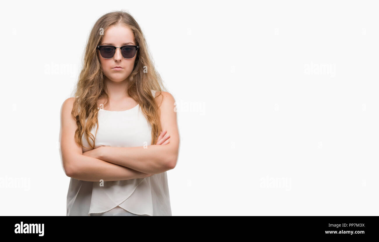 Young blonde woman wearing sunglasses skeptic and nervous, disapproving expression on face with crossed arms. Negative person. Stock Photo