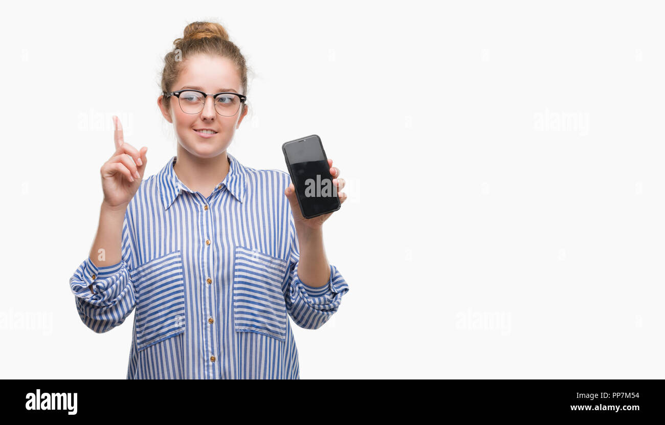 Young blonde woman using smartphone surprised with an idea or question pointing finger with happy face, number one Stock Photo