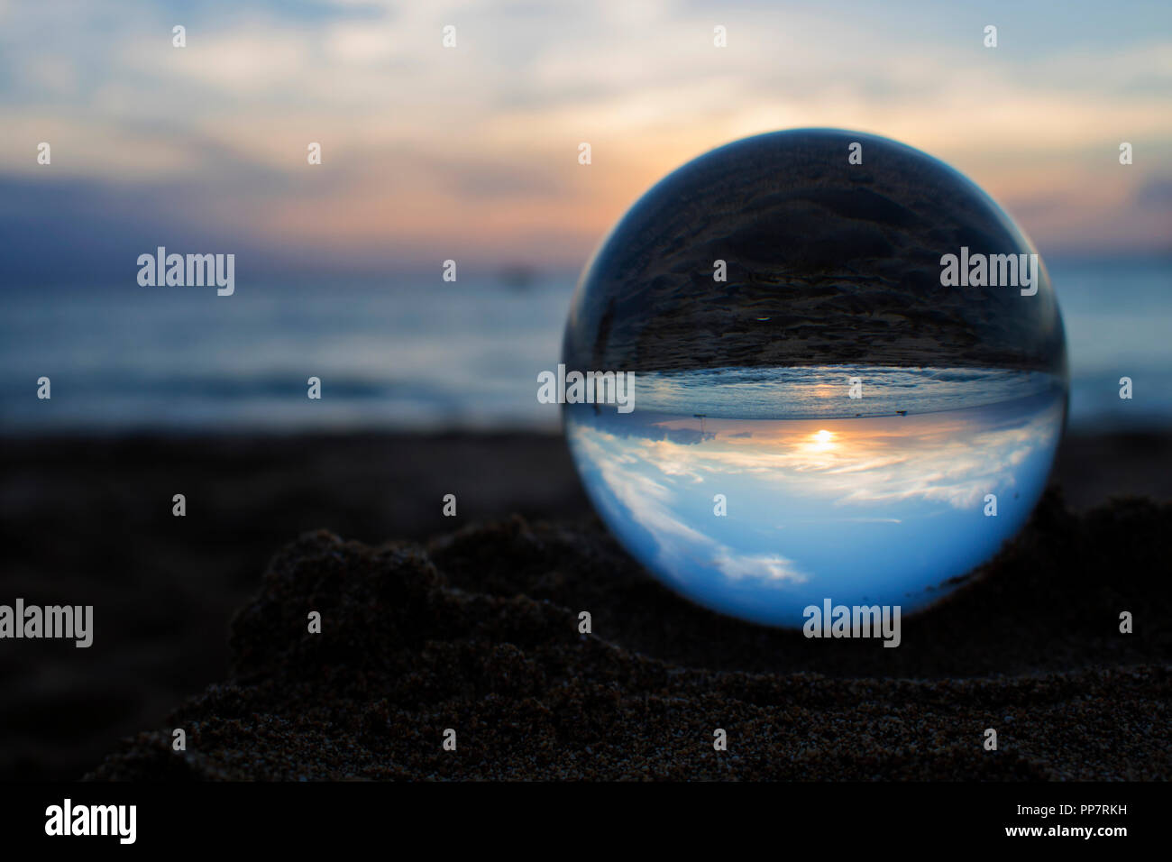 Sun on Horizon over Ocean Captured in Glass Ball on Beach Stock Photo ...