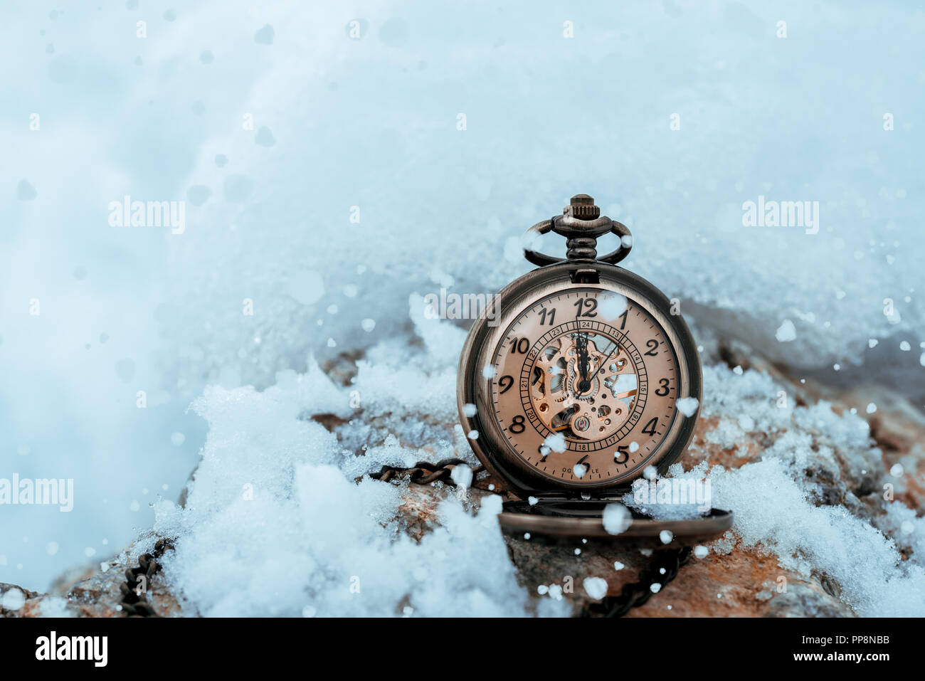 New year clock before midnight. Antique pocket watch in the snow Stock Photo