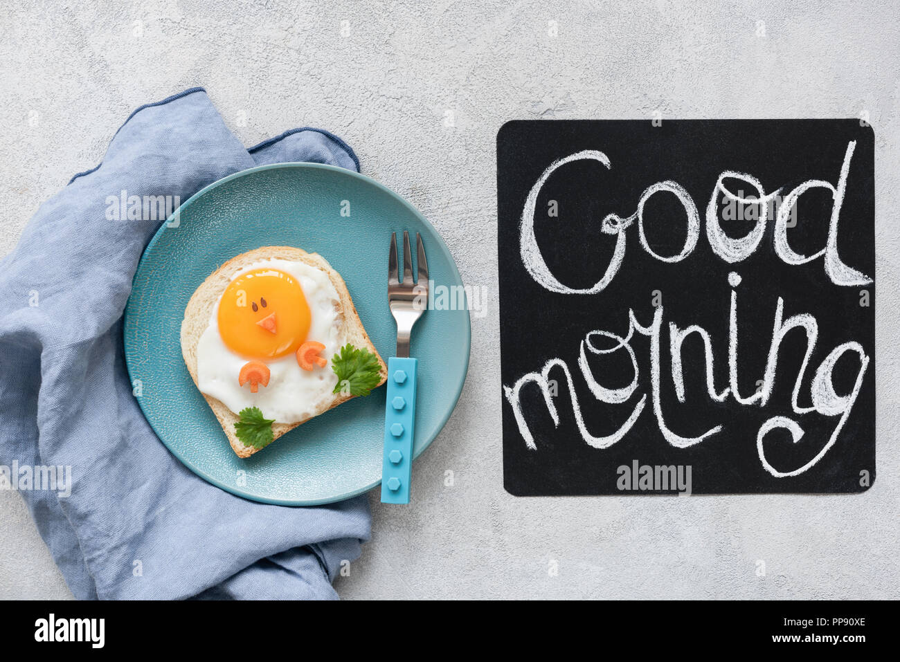 Breakfast food kids. Funny toast with egg and good morning text on a chalkboard. Top view Stock Photo