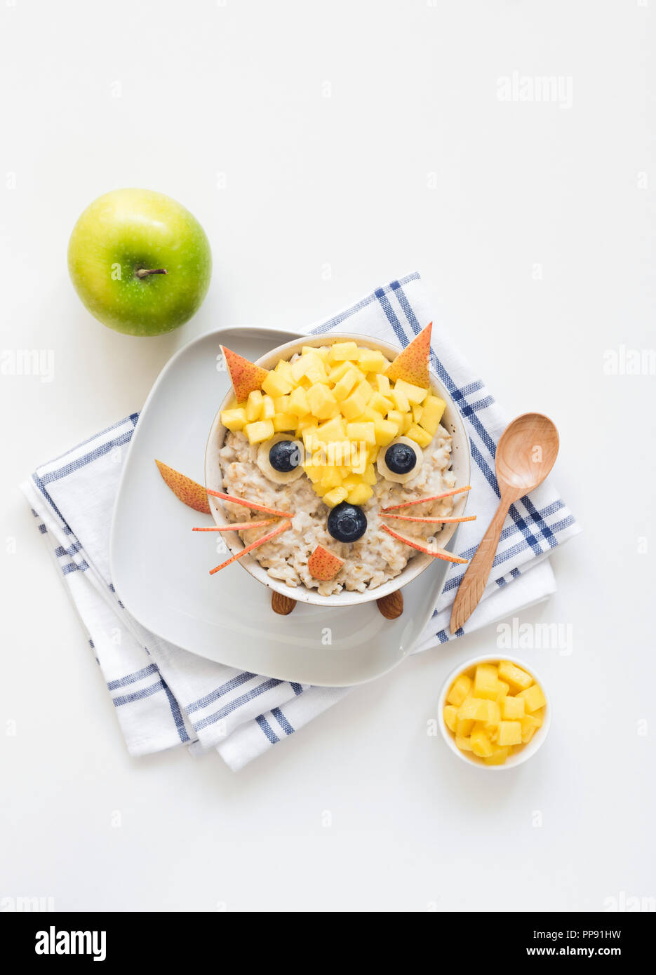 Oatmeal porridge with cute funny face, kids breakfast. Good morning breakfast for kids, food art. White background Stock Photo