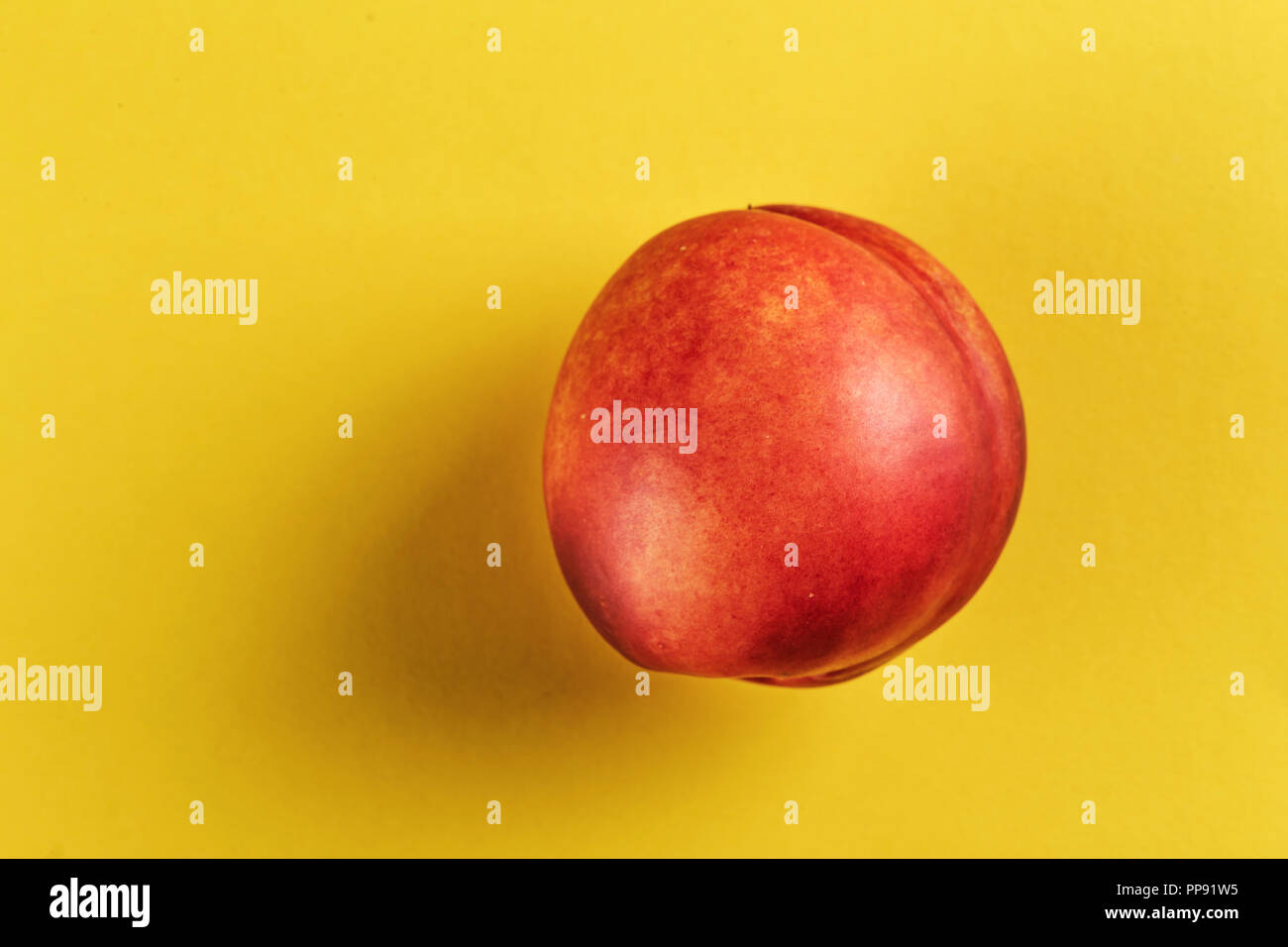 ripe nectarine on a yellow background, space for text. Stock Photo