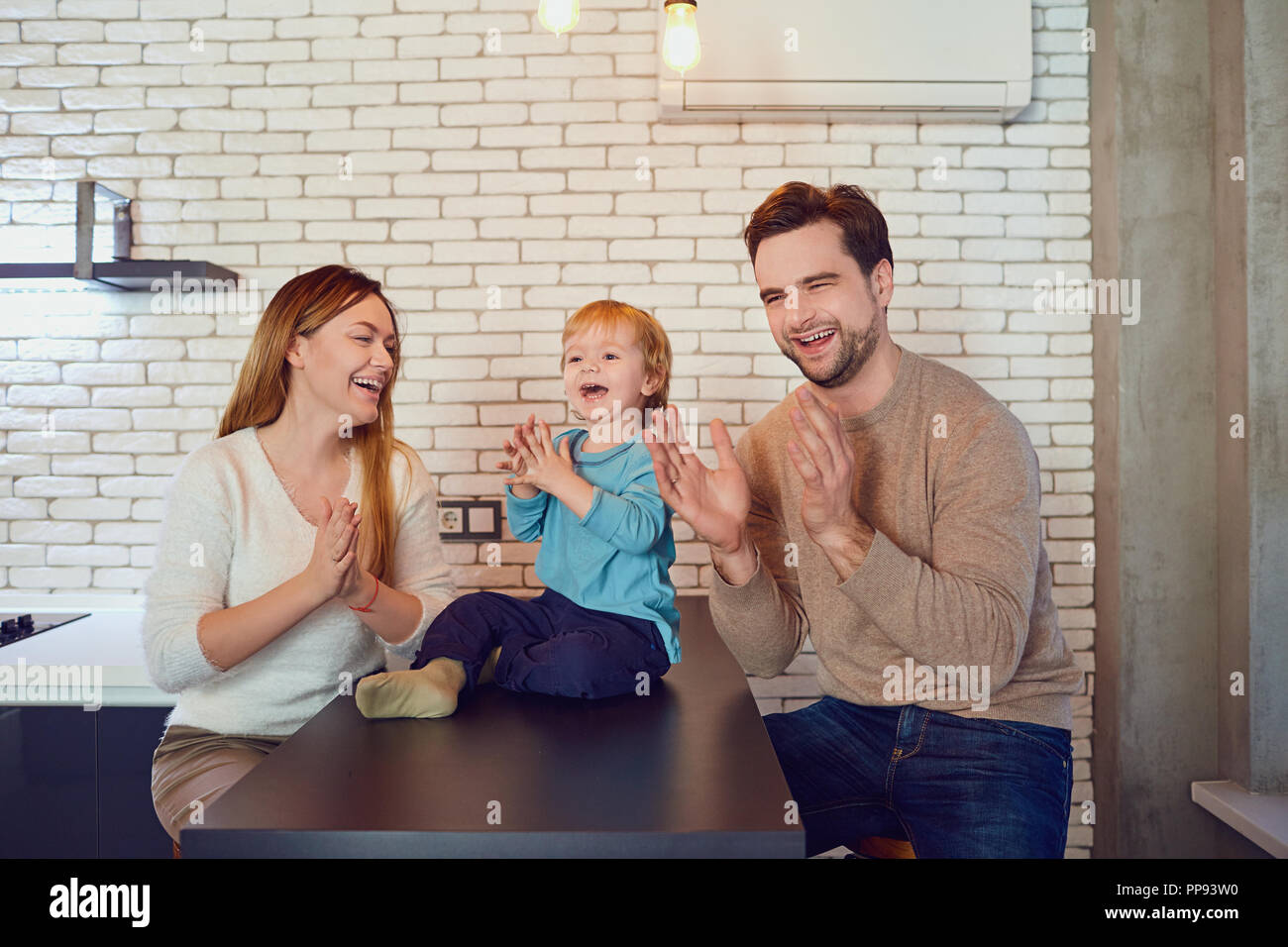 A happy family plays with a child indoors Stock Photo