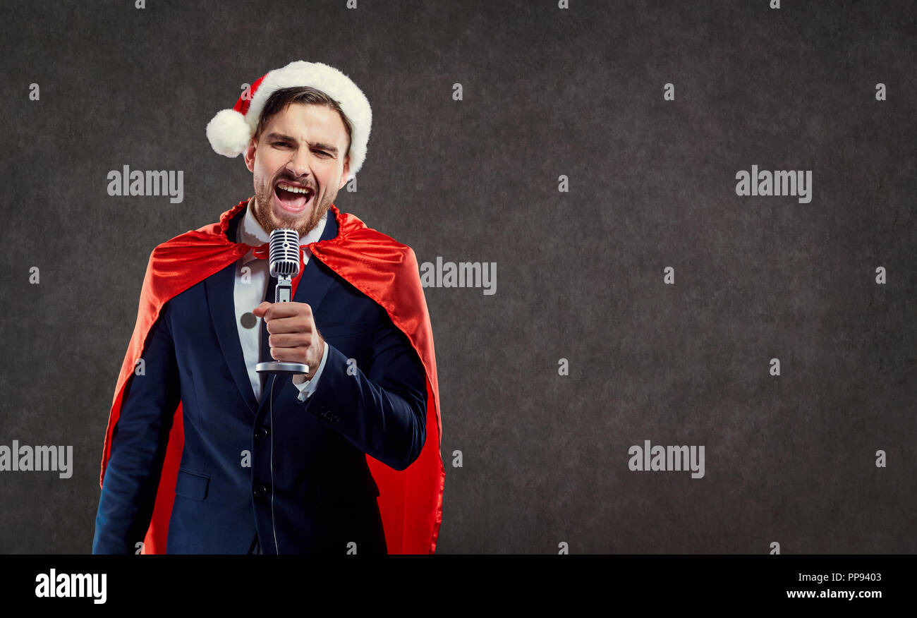 Businessman in Santa Claus costume superhero sing song Stock Photo