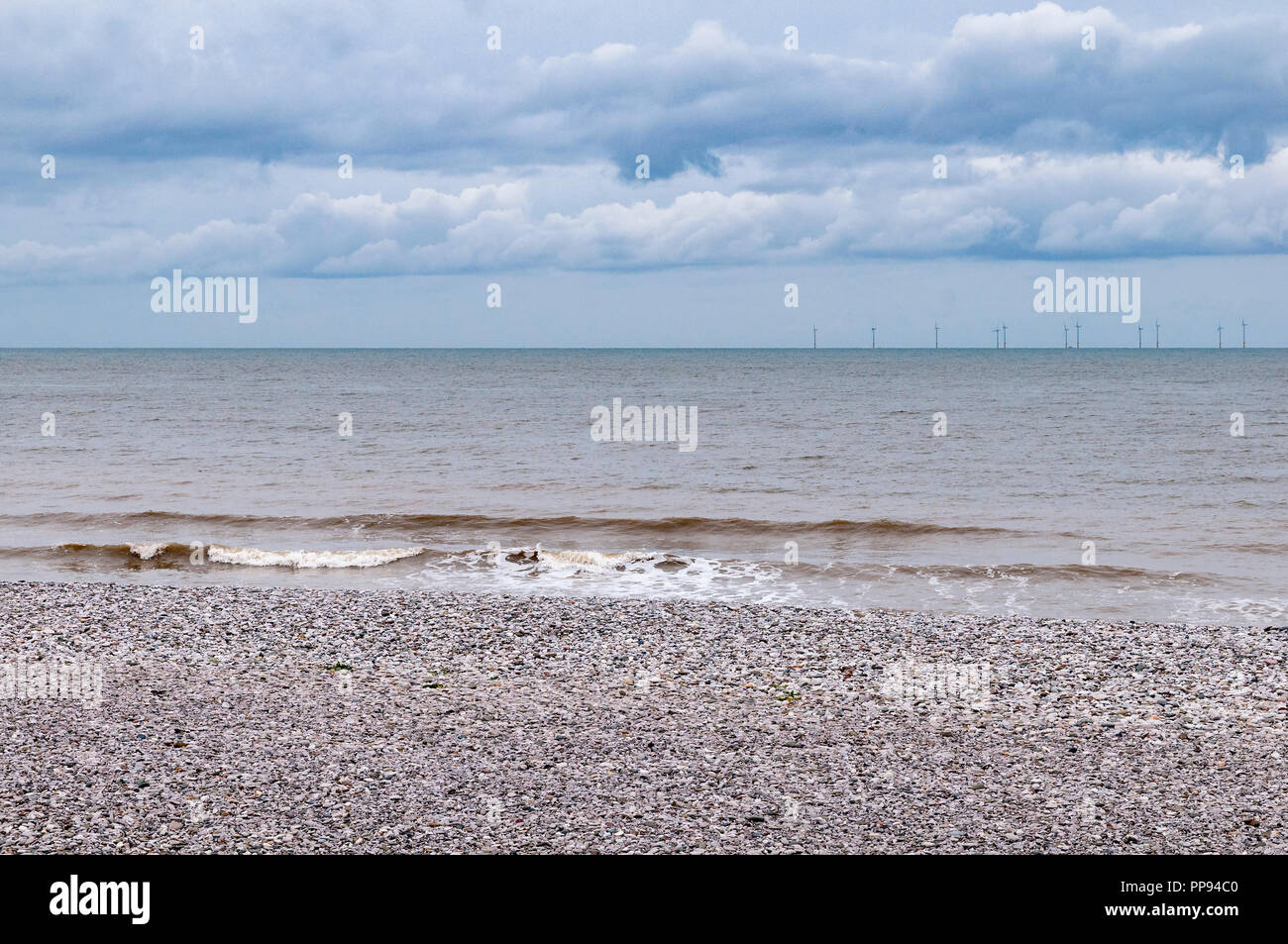 Cold grey day stony beach grey sea. Stock Photo