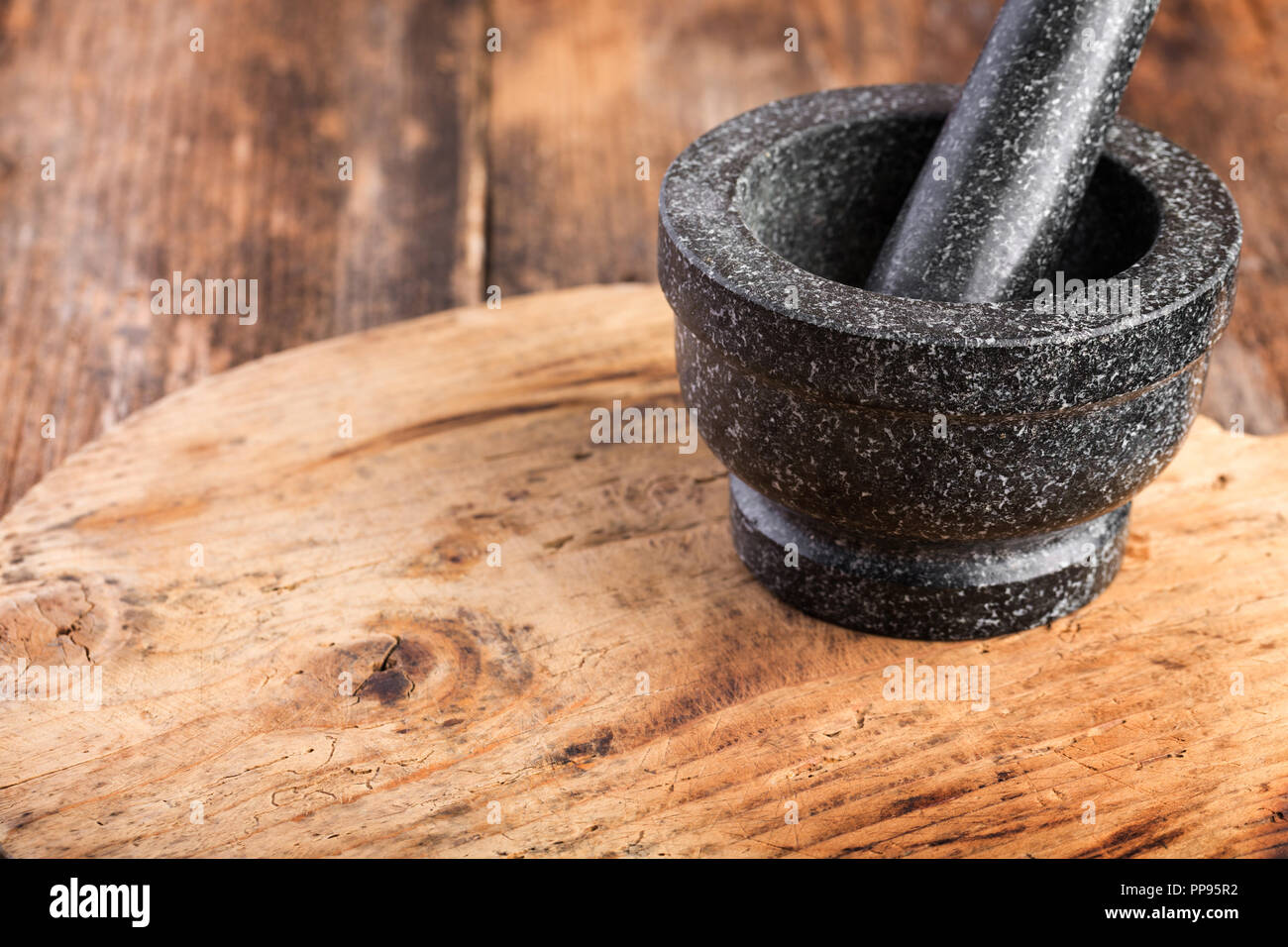 Stone mortar and pestle on wooden table, exotic cooking tool Stock