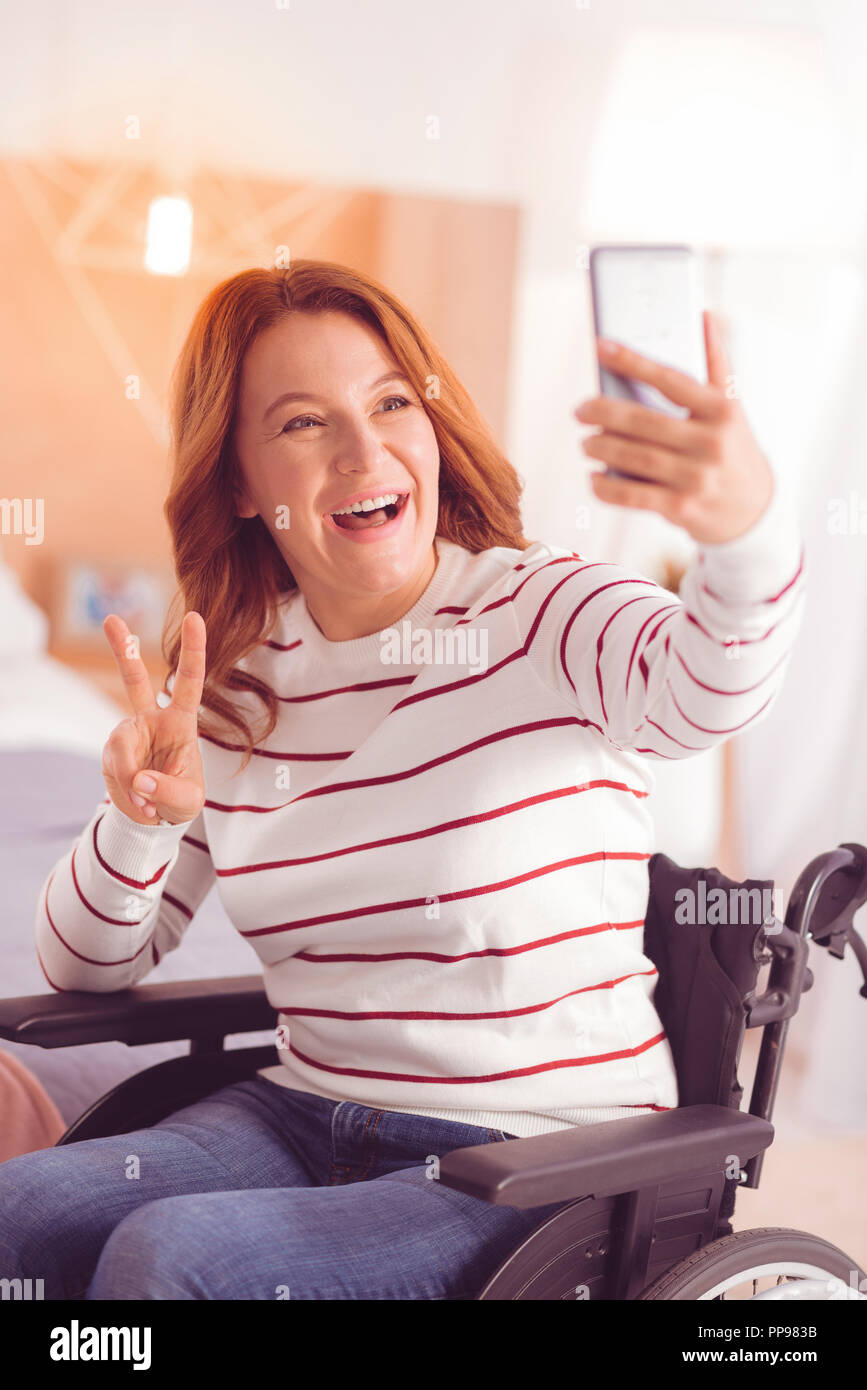 Positive woman making selfies in the wheelchair Stock Photo - Alamy