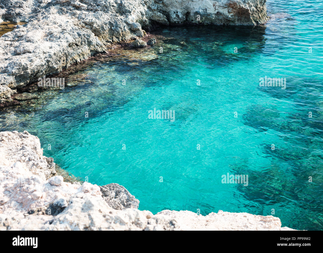 Blue water in a rocky cove near Ognina, Siracusa, Sicily, Italy Stock Photo