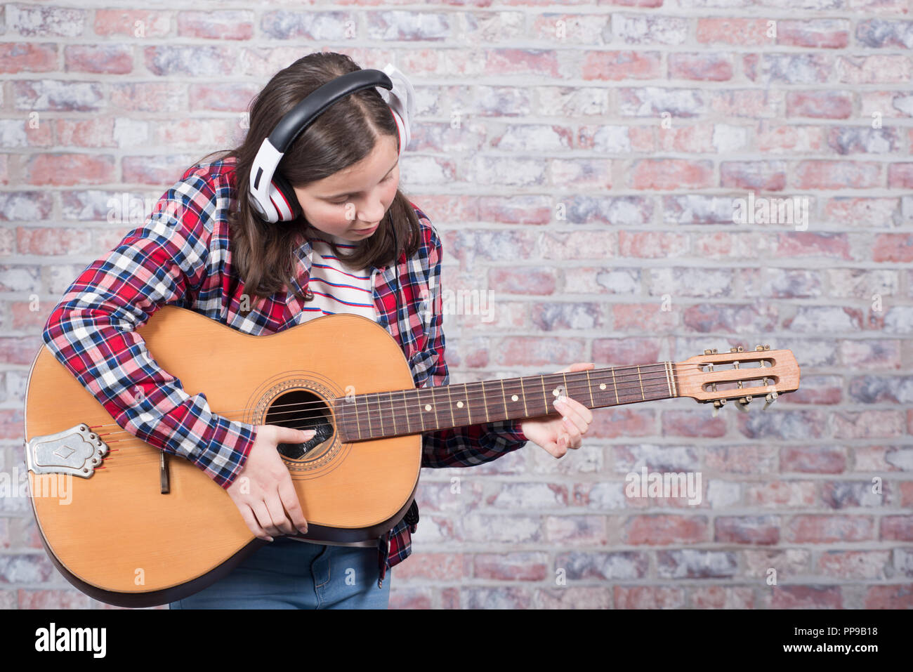 a young teenager girl playing an acoustic guitar Stock Photo - Alamy