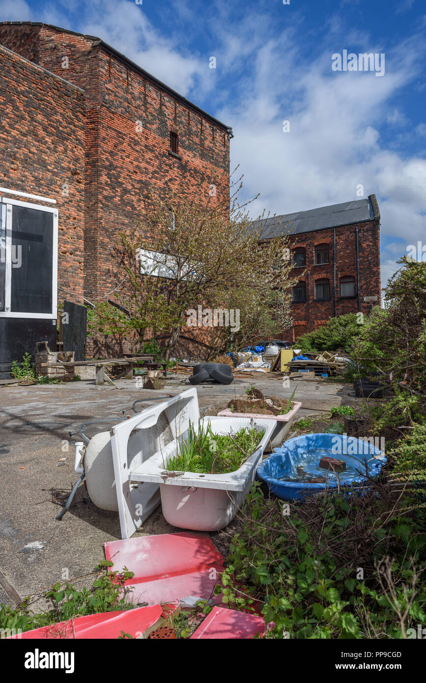 Discarded junk around old brick warehouses in LIverpool docklands. Stock Photo