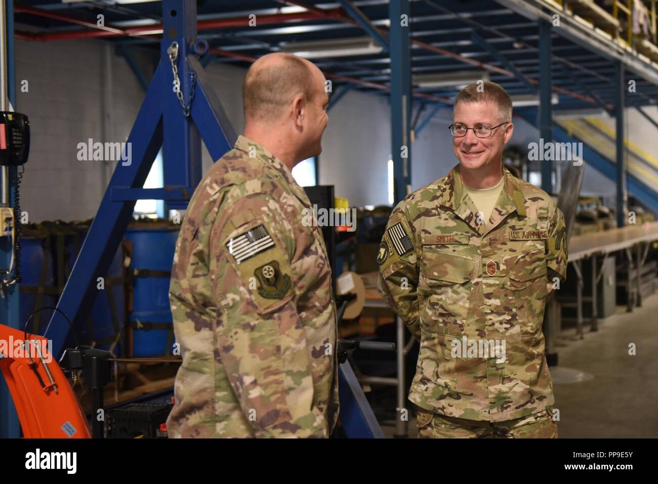 U.S. Air Force Chief Master Sgt. Gregory Smith, right, command chief master sergeant of Air Force Special Operations Command, talks with Master Sgt. Philip Shelton, an air cargo specialist with the 193rd Special Operations Wing, Middletown, Pennsylvania, Aug. 16, 2018. Shelton briefed Smith on the many projects that Airmen are currently working on in the 193rd Special Operations Logistics Readiness Squadron. Smith visited in an effort to learn more about the 193rd SOW mission and have the opportunity to meet Air Commandos from across the wing and thank them for their hard work in support of AF Stock Photo