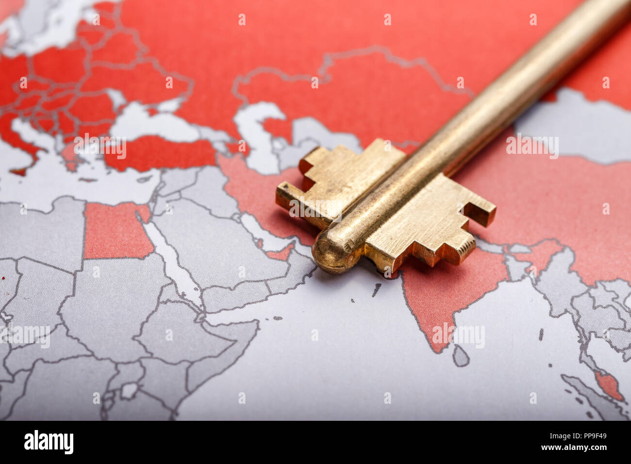 key from the modern door on the contour map of the world. conceptual image implying openness of the world Stock Photo