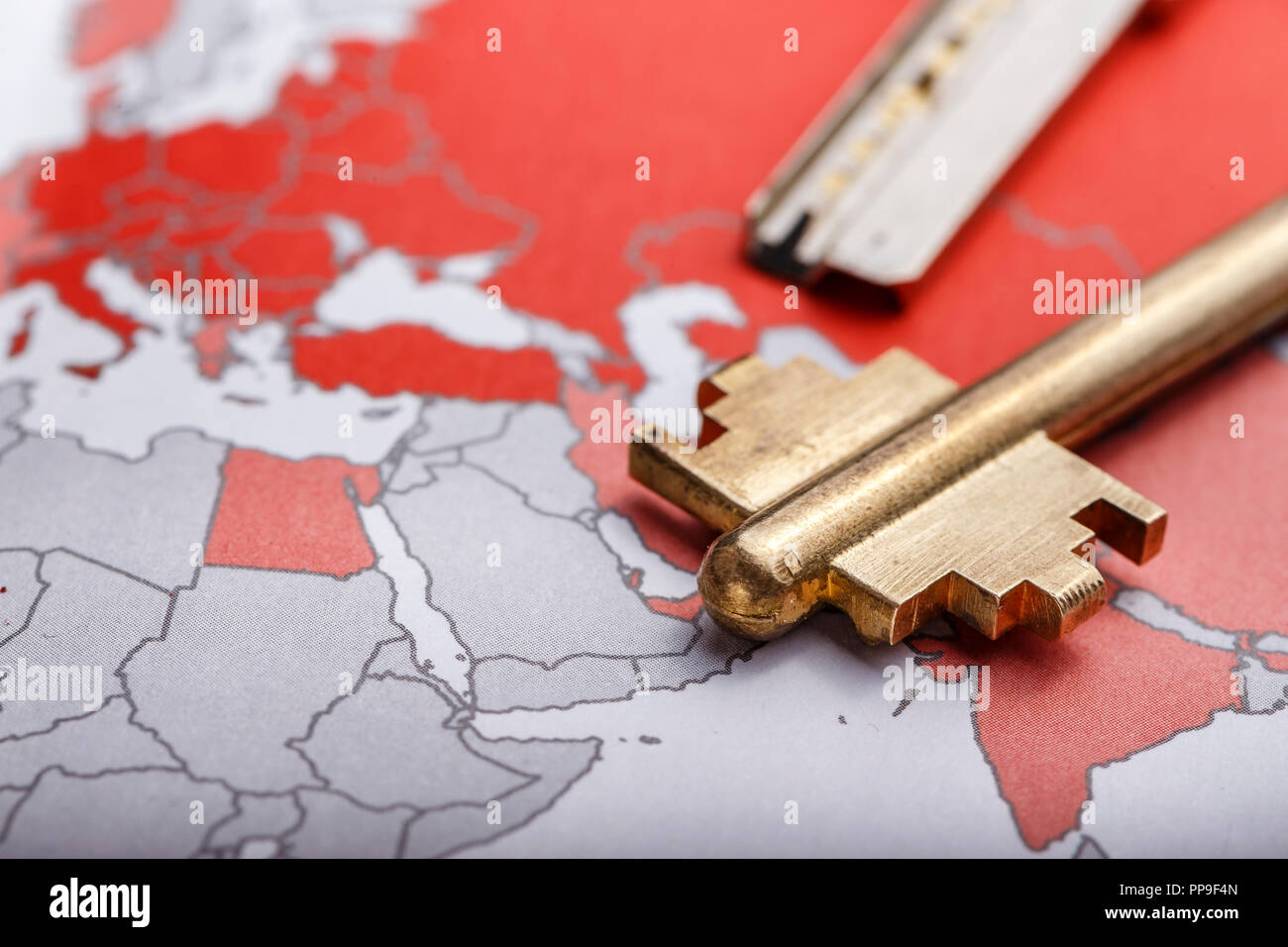 key from the modern door on the contour map of the world. conceptual image implying openness of the world Stock Photo