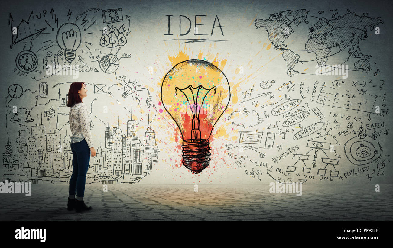 Side view of a pensive young woman looking at the wall with colorful light bulb and business sketch. Uniqueness of the idea and genius concept. Stock Photo