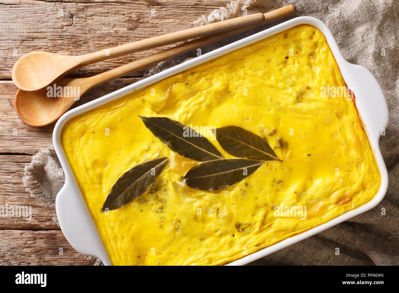 Delicious hot South African food Bobotie spicy minced meat with whipped eggs close-up in a baking dish on the table. horizontal top view from above Stock Photo