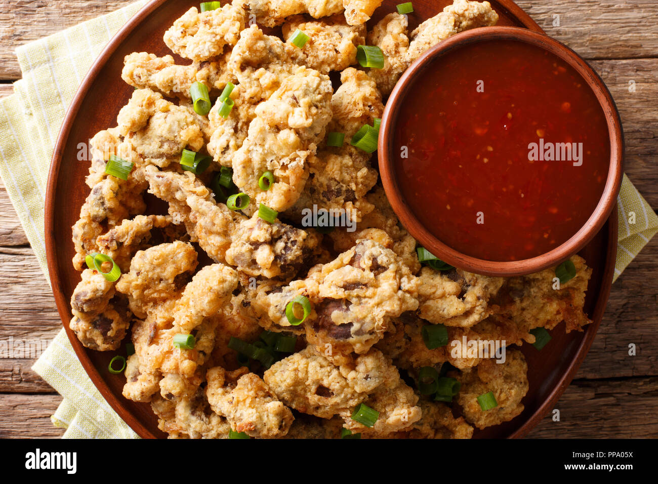 Spicy crispy fried chicken gizzards served with green onions and spicy