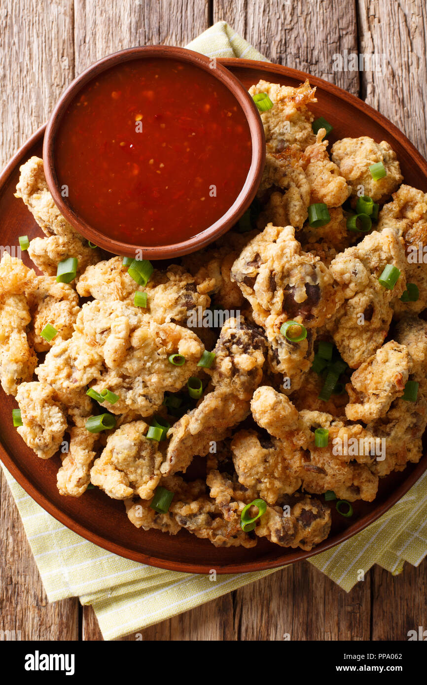 Spicy crispy fried chicken gizzards served with green onions and spicy