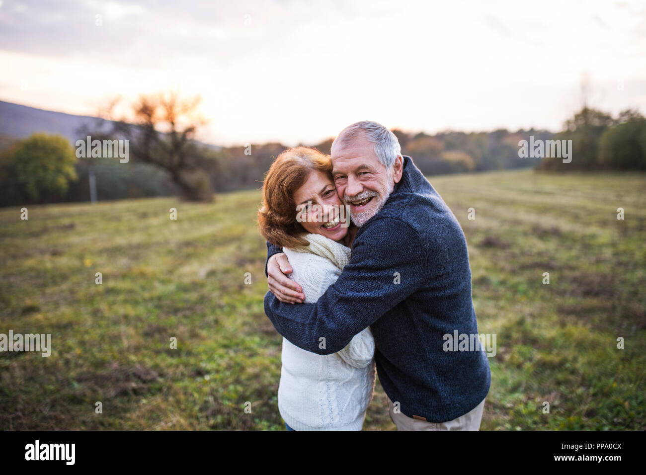 Senior couple hugging in an autumn nature at sunset Stock Photo - Alamy