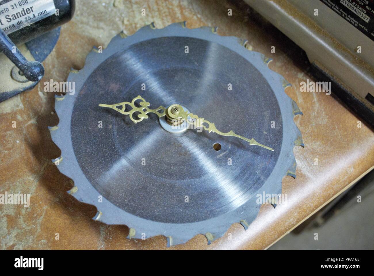 black and white saw blade clock on a work bench Stock Photo