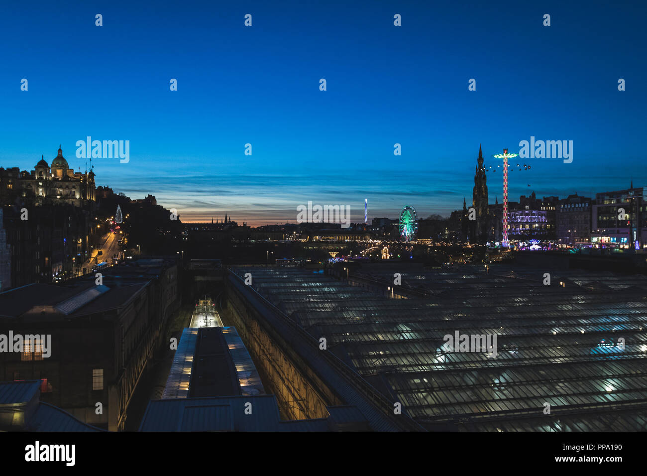 Edinburgh Castle and Christmas Market at twilight with view over train