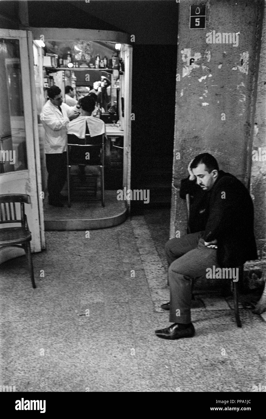 A man waiting for an haircut outside a barbers shop in East Jerusalem in 1965 Stock Photo